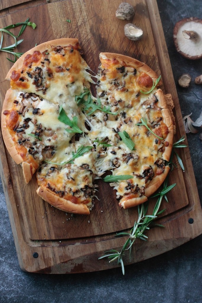 Pizza sobre tabla de madera, vertical
