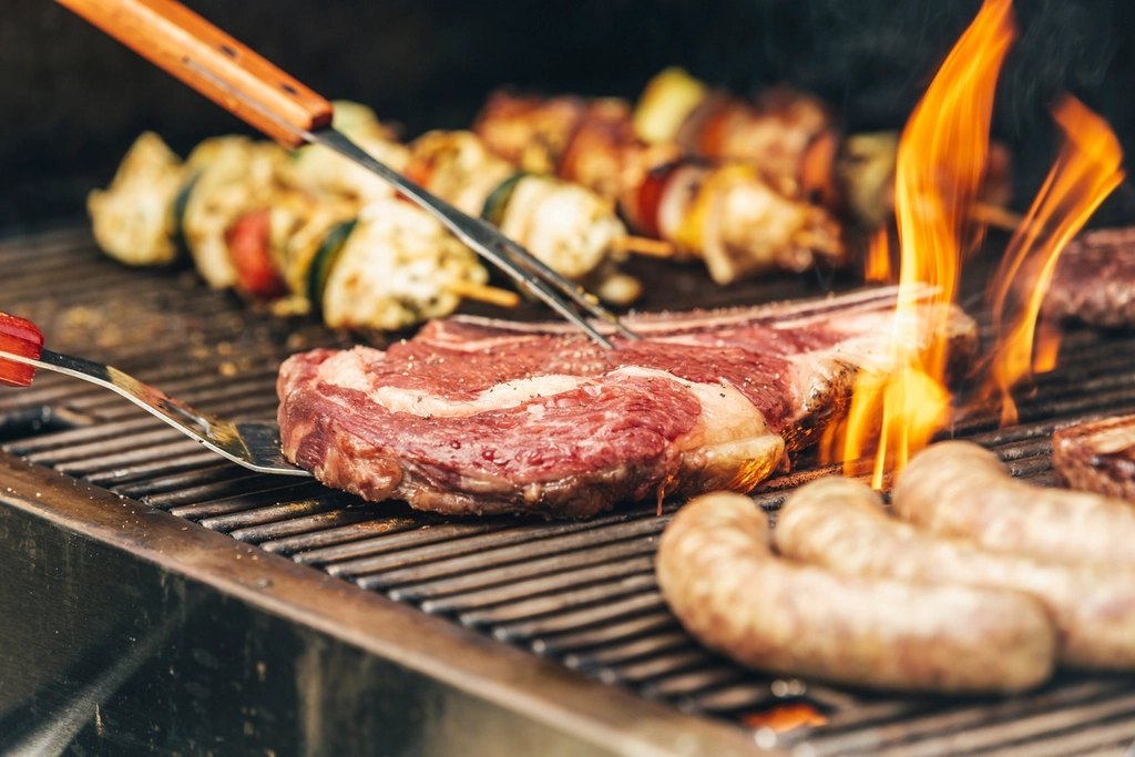 Bife y chorizos en la parrilla con fuego
